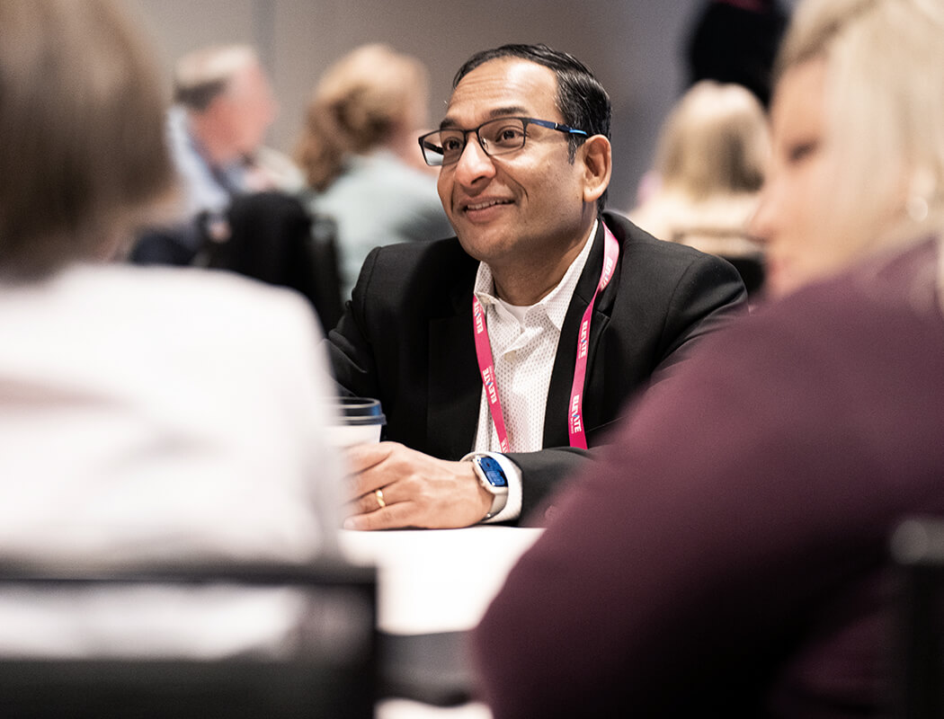 An insighter talking with colleagues at an Elevate event